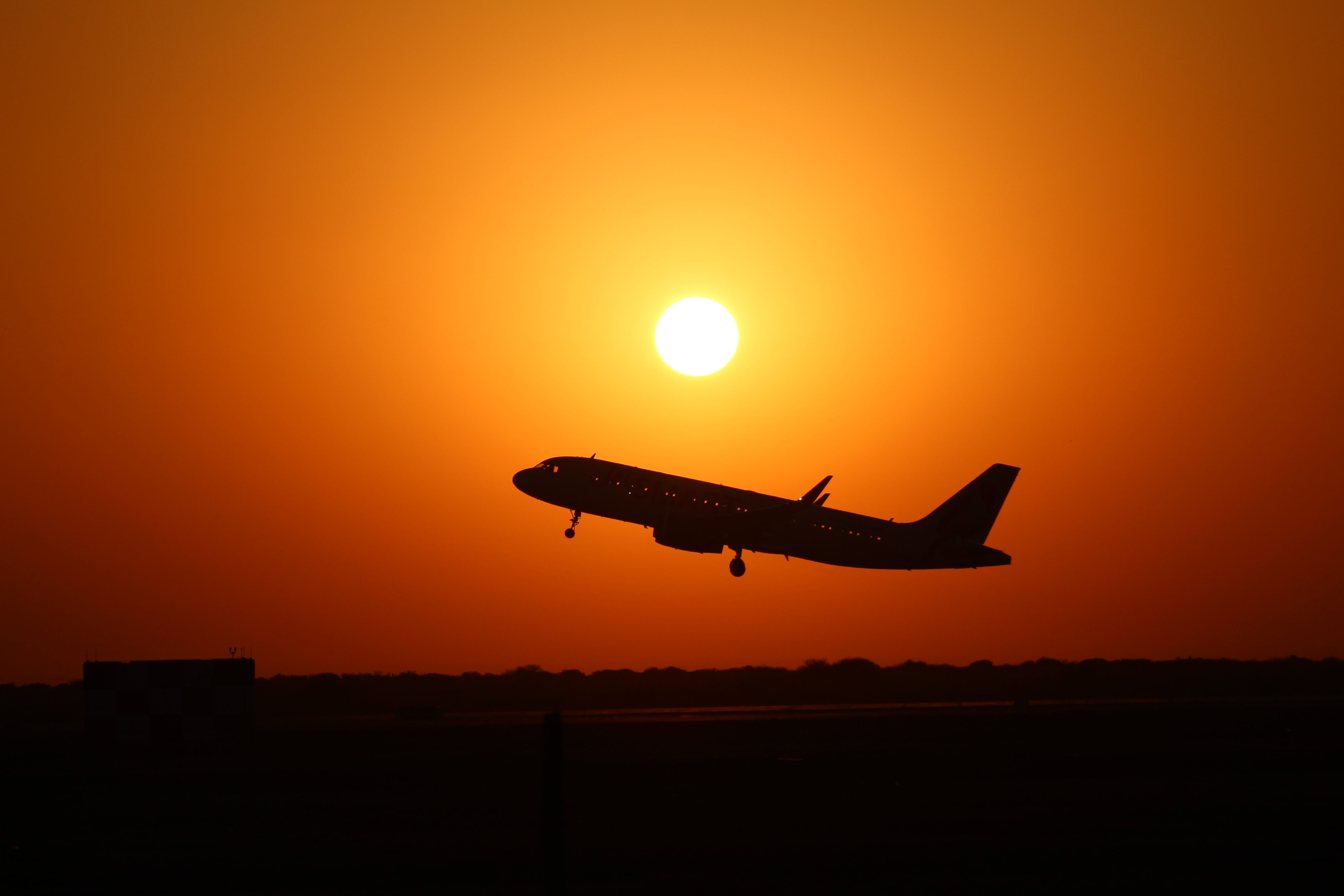 Un avion de ligne décolle au coucher du soleil