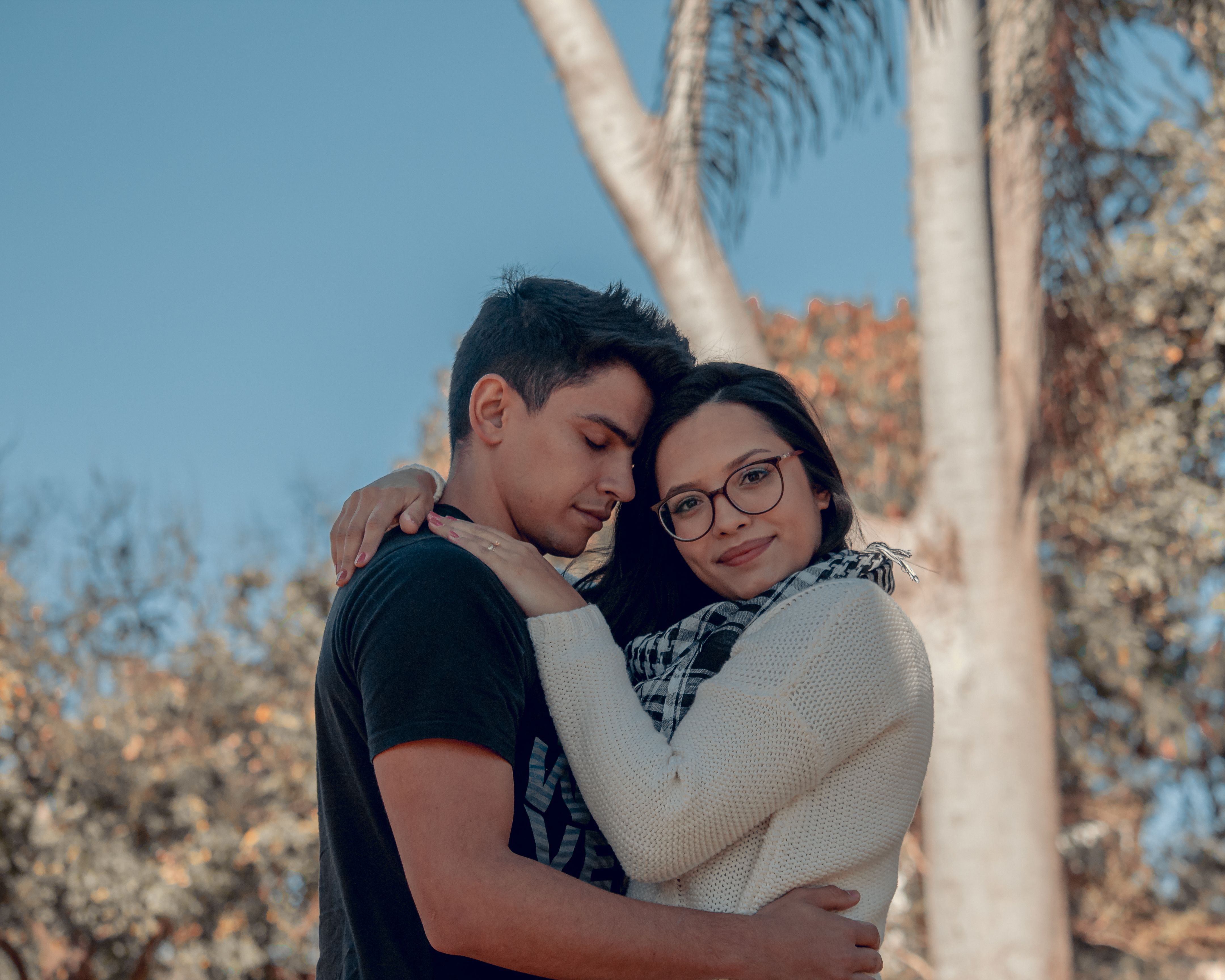 Una pareja sonriente se abraza al aire libre
